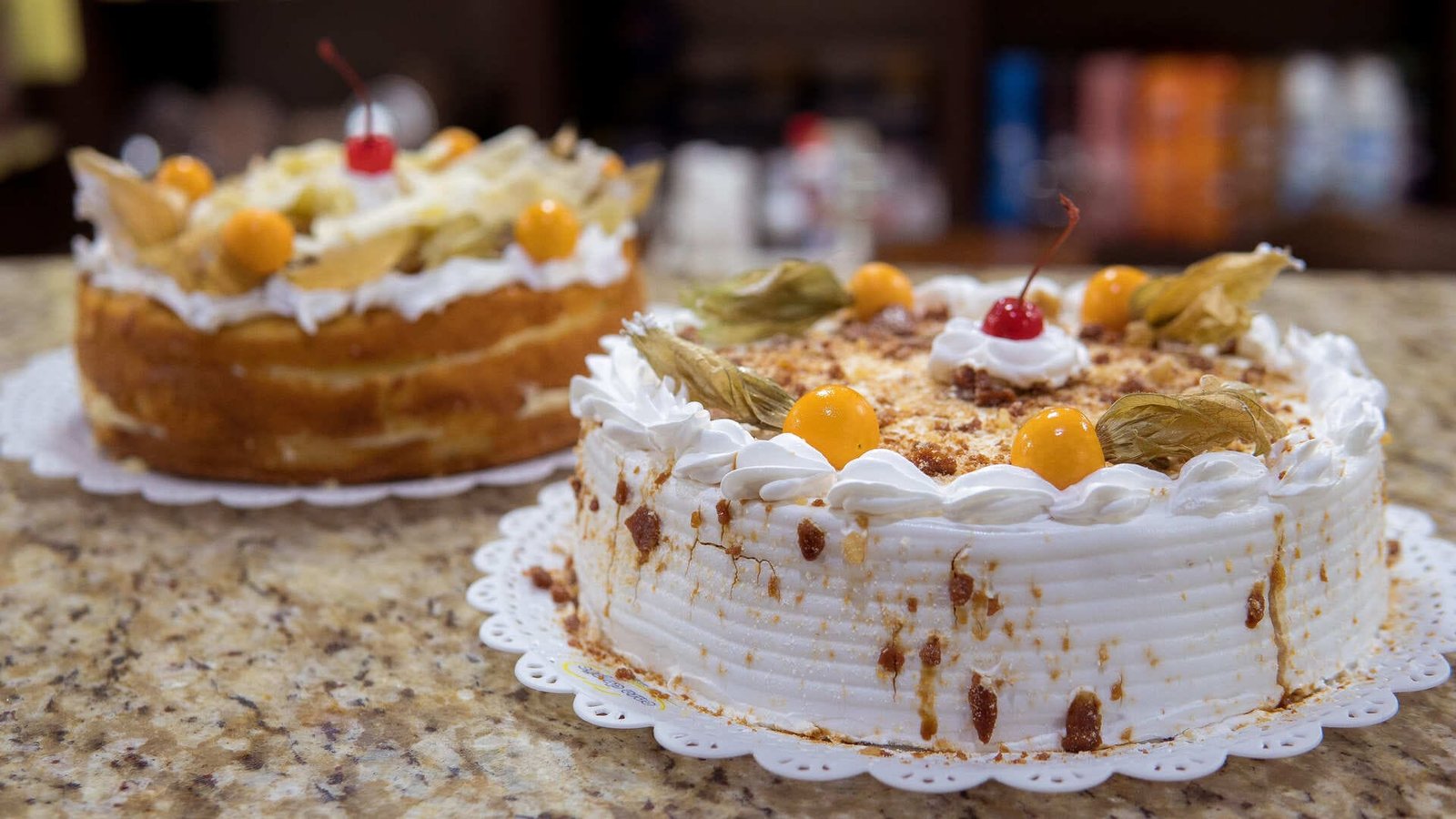 Bolos e tortas decorados com frutas no balcão da Casa do Pão